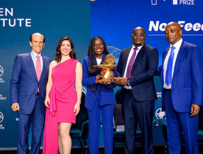 White man, white woman, black woman holding a trophy, and two black men standing on stage